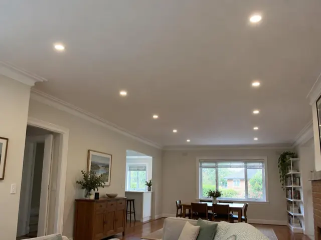 Living room ceiling with flush LED downlights in a cream interior with timber floors in Artarmon